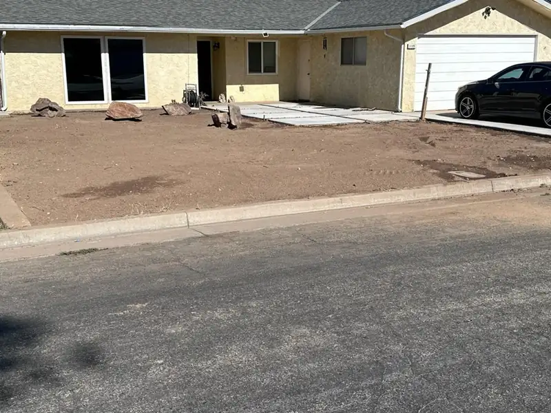 Front yard graded and leveled beside the driveway, ready for landscaping