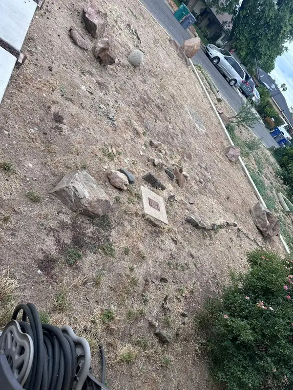 Yard cleared and graded with landscape boulders staged